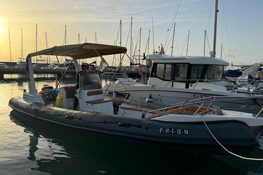 A marina with several boats docked, including a motorboat with a canopy and a white cabin boat. 3