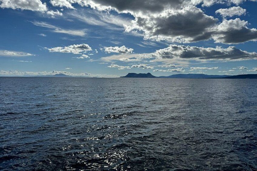 A calm sea with a clear sky and distant mountains. 5