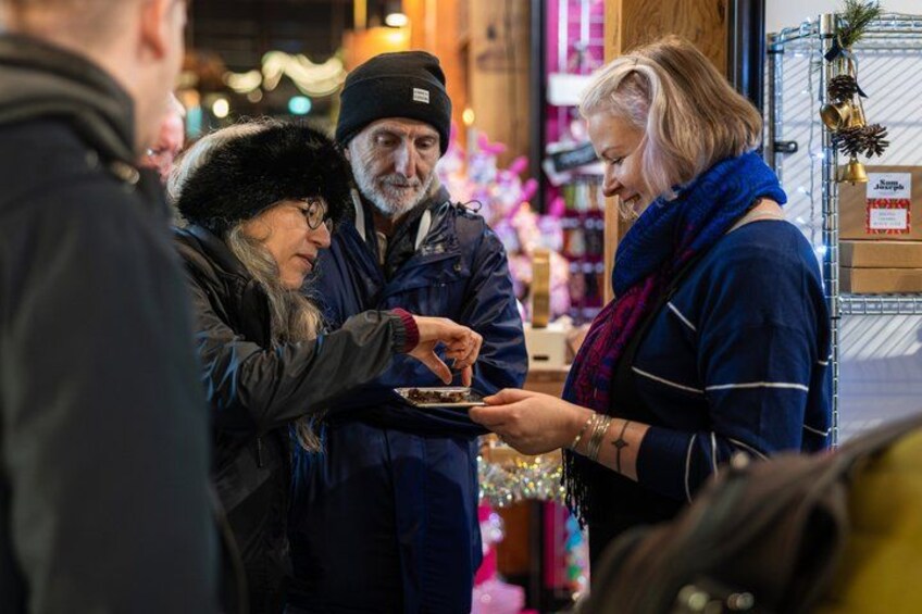 People interacting in a market setting with visible merchandise and festive decorations. 4