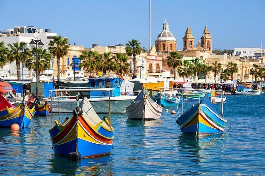 A harbor with colorful boats, a church, and palm trees. 5