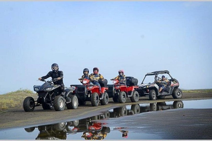 Four off-road vehicles on a muddy path with puddles. 1
