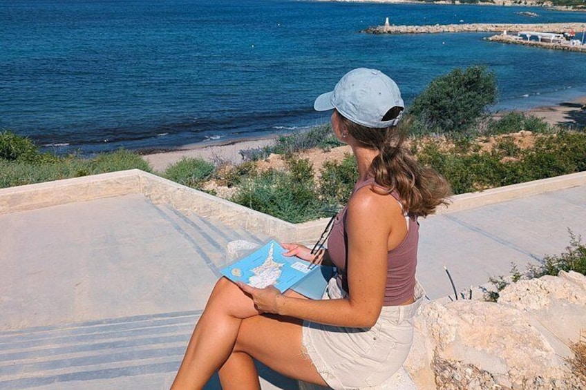 A person sitting on a concrete ledge overlooking a body of water. 2