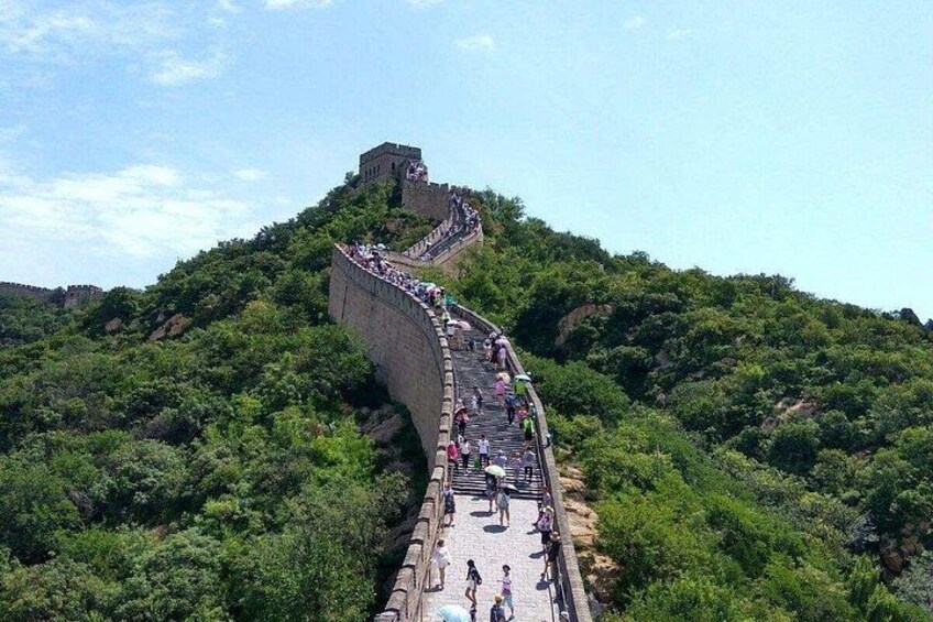 The Great Wall of China winding through lush green hills. 1