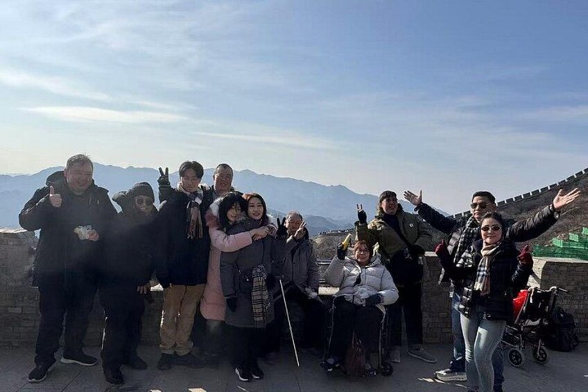 A group of people at a historical site with a clear sky and mountains in the background. 2