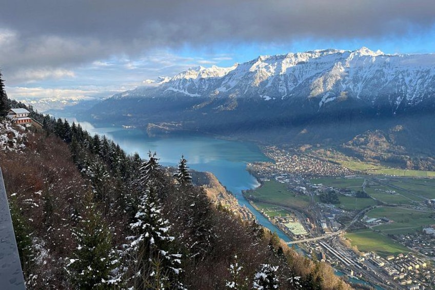 Un paisaje montañoso con un lago, árboles nevados y un pueblo en la falda de la montaña. 4