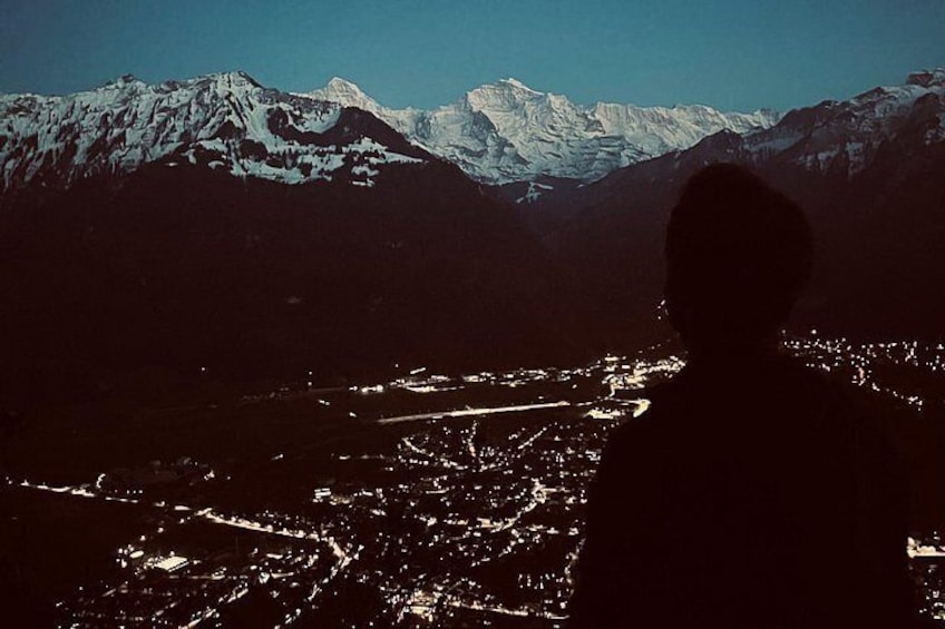 Un paisaje montañoso con picos nevados y la silueta de una persona. 3