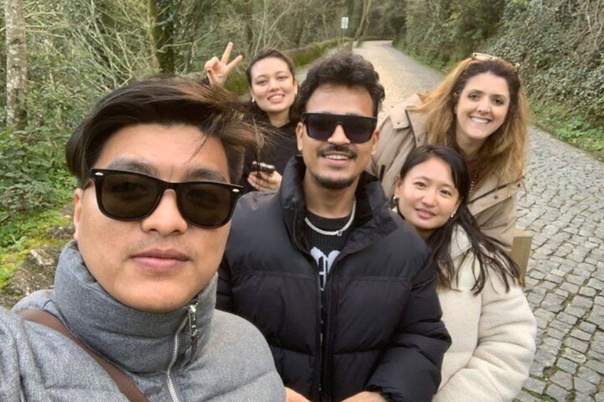 A group of people on a cobblestone path surrounded by greenery. 5