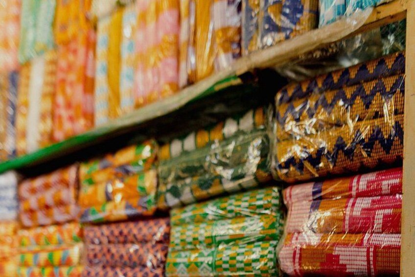 A variety of colorful fabrics stacked on shelves. 2