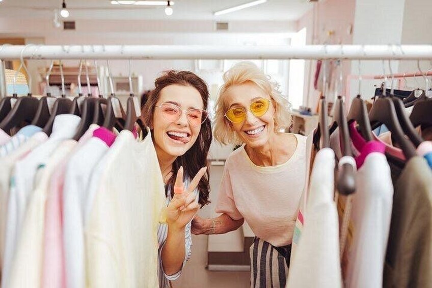 Two people in a clothing store, surrounded by racks of various garments. 5