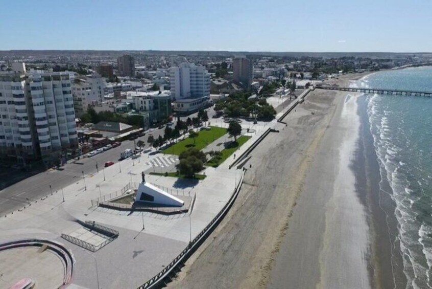 Un paisaje urbano costero con playa, paseo marítimo y edificios modernos. 3