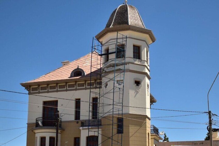 Un edificio con una torre, andamios y un cielo azul despejado. 5
