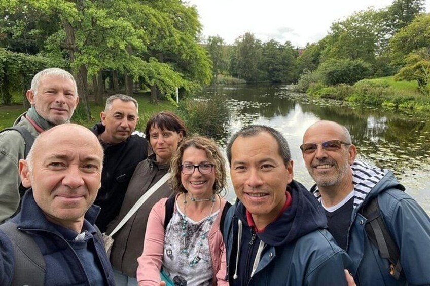 Een groep mensen staat bij een rustige rivier, omringd door weelderige begroeiing. 1