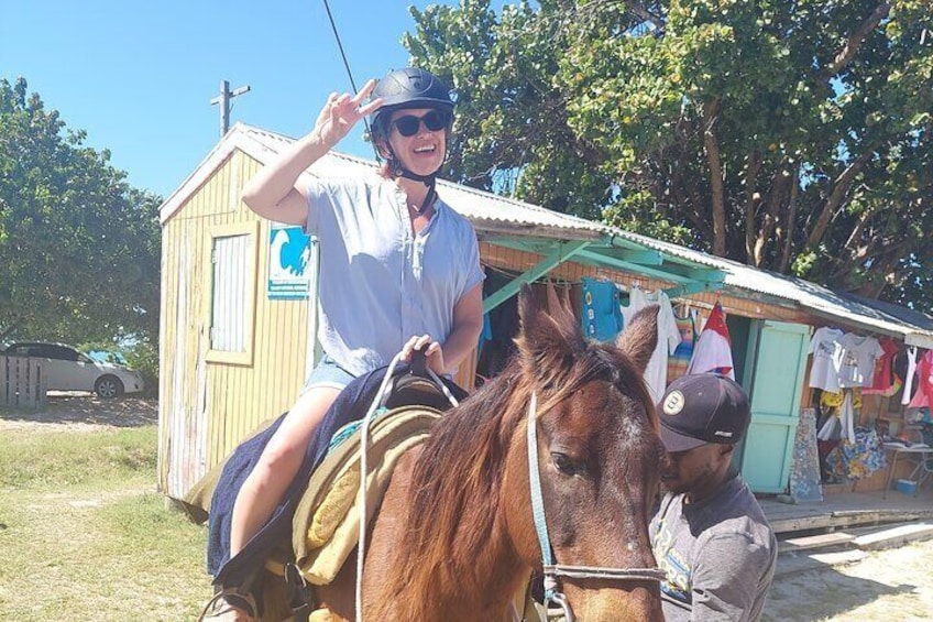 A person riding a horse in front of a small wooden building with a cross on top. 5