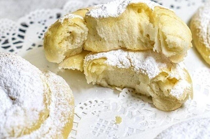 A pastry with powdered sugar on a lace doily. 4