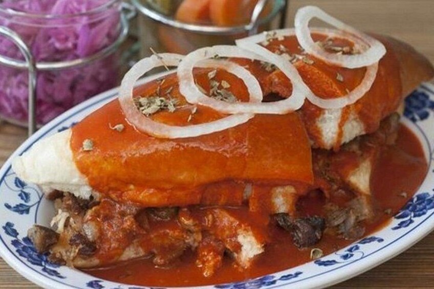 A plate of stuffed bread with tomato sauce and onions. 2