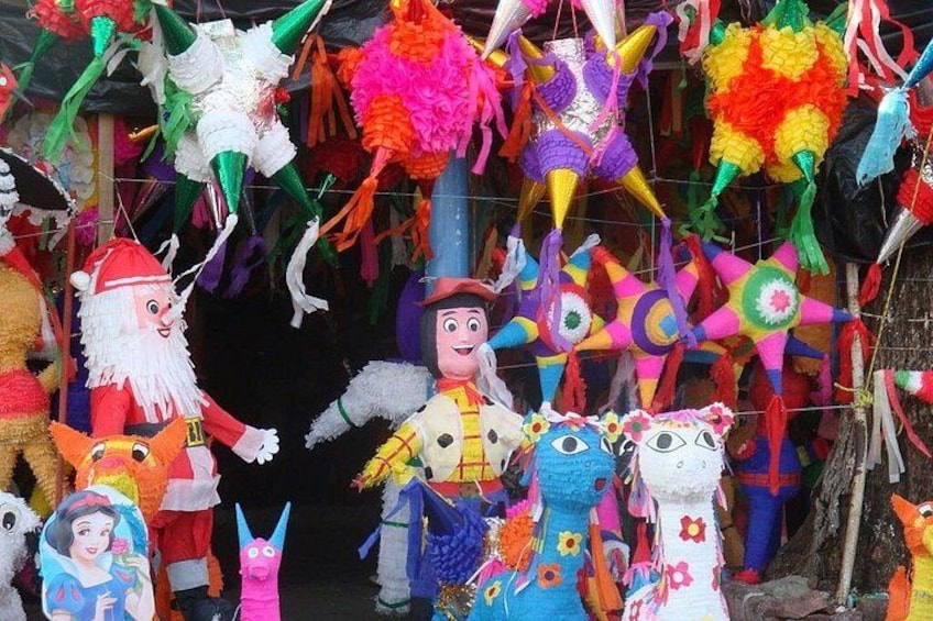 Ett stort utbud av färgglada piñatas och dekorationer, bland annat figurer av jultomten, Woody från Toy Story och andra karaktärer. 1