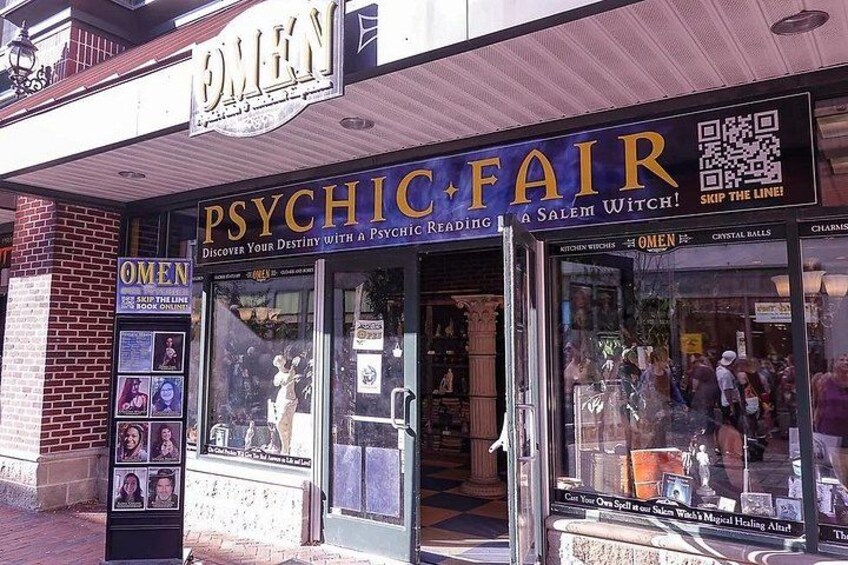 Ein Schaufenster mit einem Schild, auf dem 'PSYCHIC FAIR' und 'OMEN' steht. 2