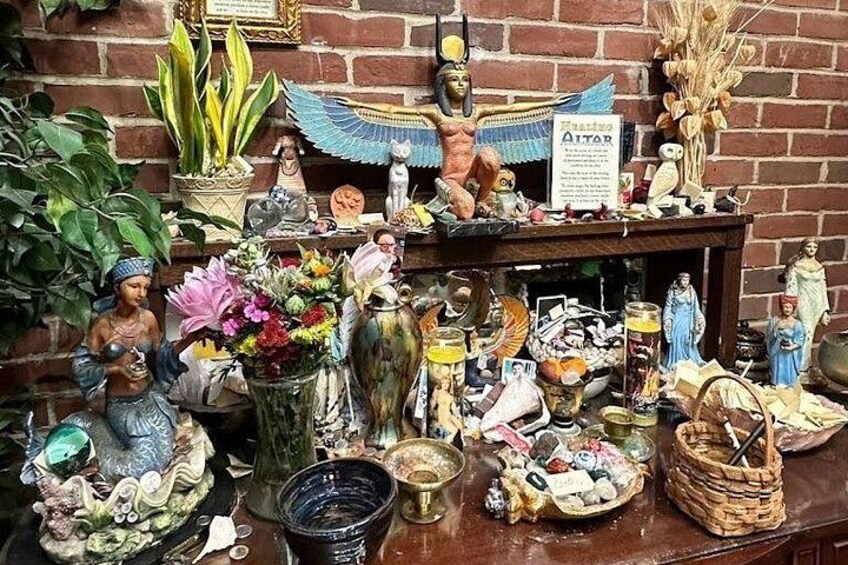 Ein überladener Altar mit religiösen Figuren, Blumen und verschiedenen Gaben. 1