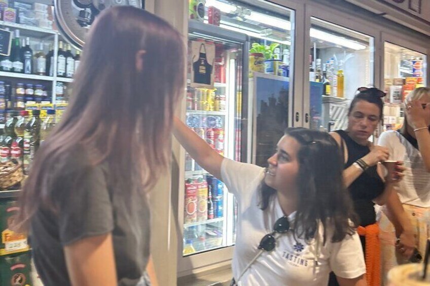 En person med långt hår i en butik med kylda hyllor. 3
