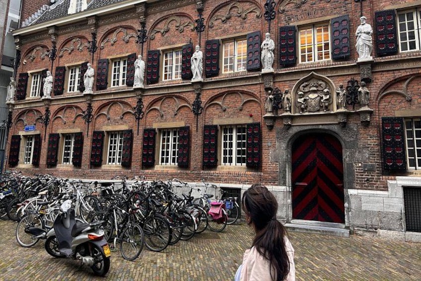 A historic building with multiple statues and a red door. 4
