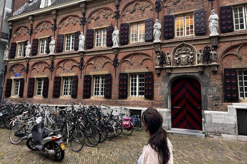 A historic building with a red door and multiple bicycles parked in front. 4
