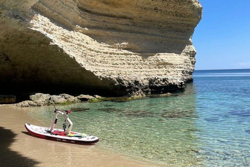 A person paddleboarding near a rocky coastline. 2