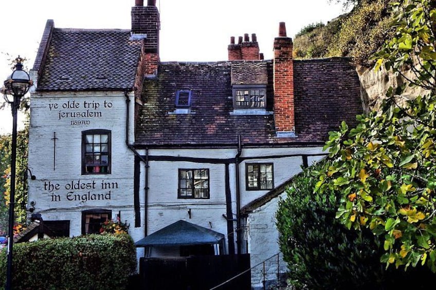 A traditional white building with a sign that reads 'The oldest inn in England.' 2