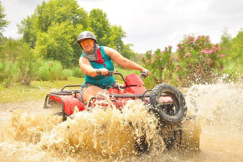 En person kører på en rød ATV gennem et mudret mark. 1