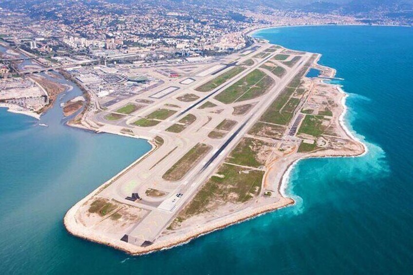 An aerial view of an airport with multiple runways and a coastline. 1