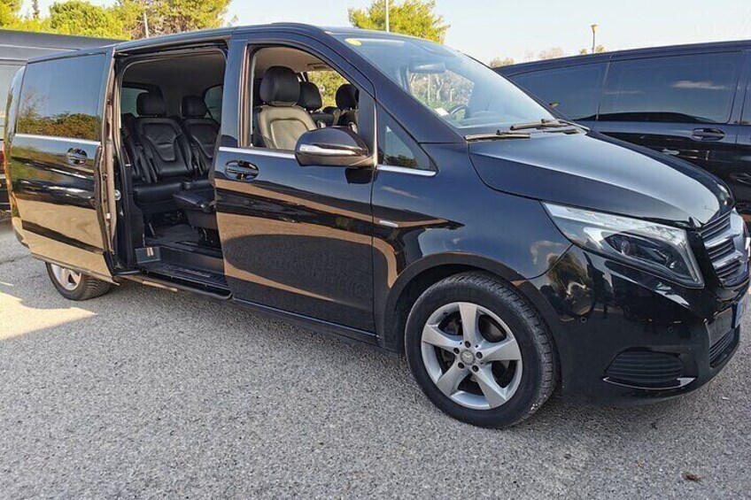 A black van parked on a gravel surface. 2