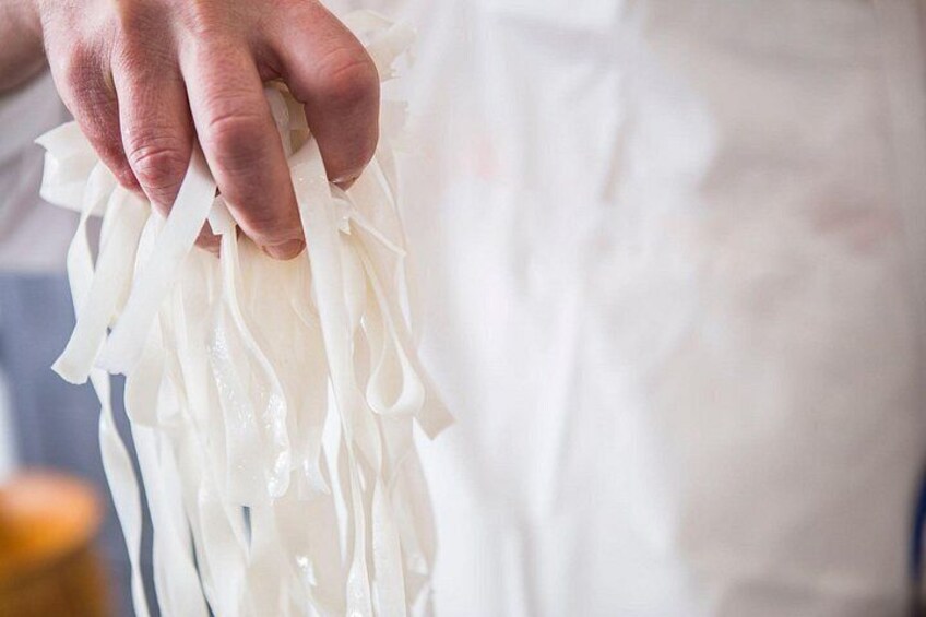 A person holding a white, translucent material, possibly a fabric or paper. 2
