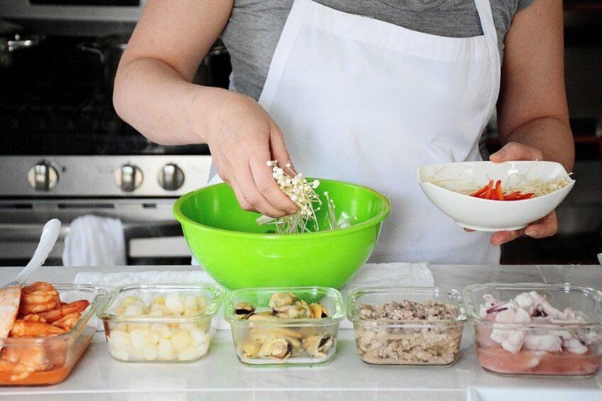 A person preparing food with various ingredients in bowls and containers. 5