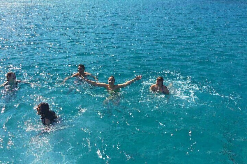 People swimming in a clear blue body of water. 4
