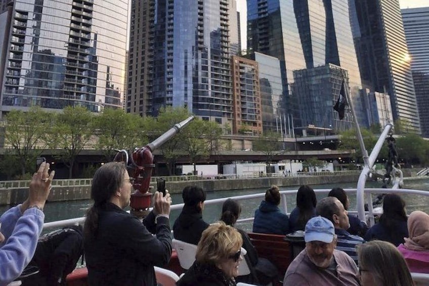 People observing a large cannon in an urban setting with modern buildings in the background. 2