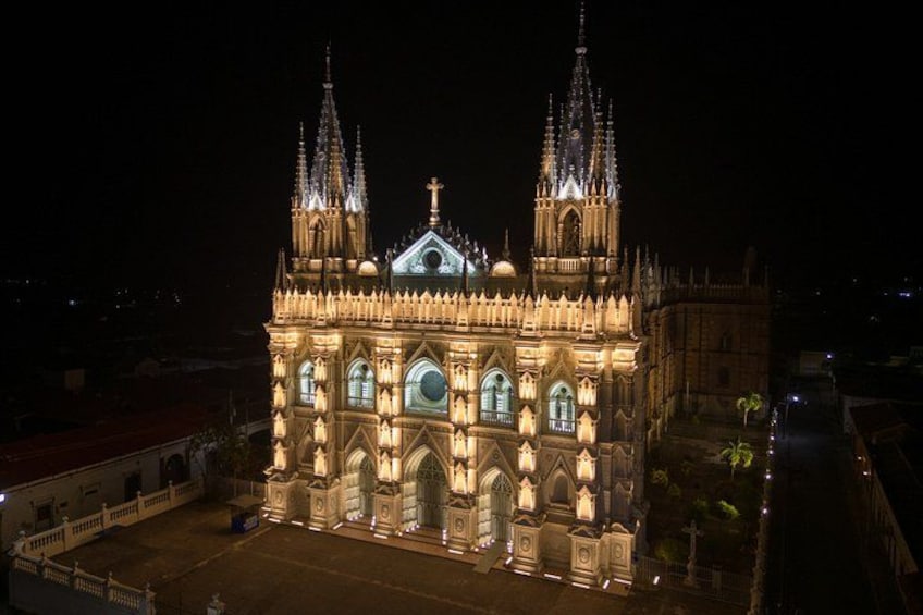 Une vaste cathédrale illuminée, dotée de deux flèches et d’un dôme central. 1