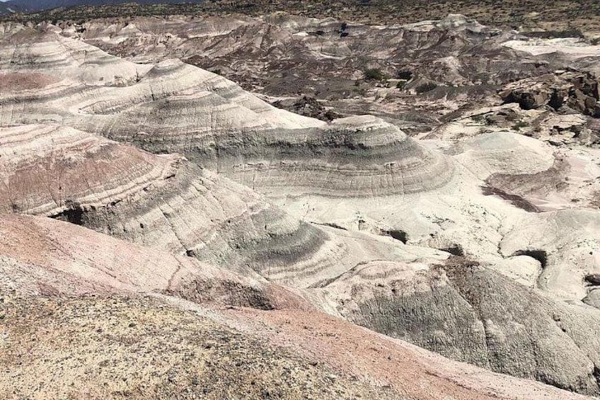 Eine Landschaft mit schichtartigen Felsformationen und zerklüftetem Gelände. 4