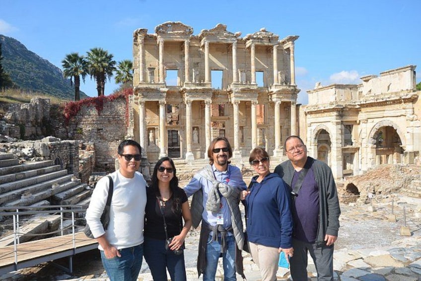 A group of people standing in front of ancient ruins with columns and steps. 1