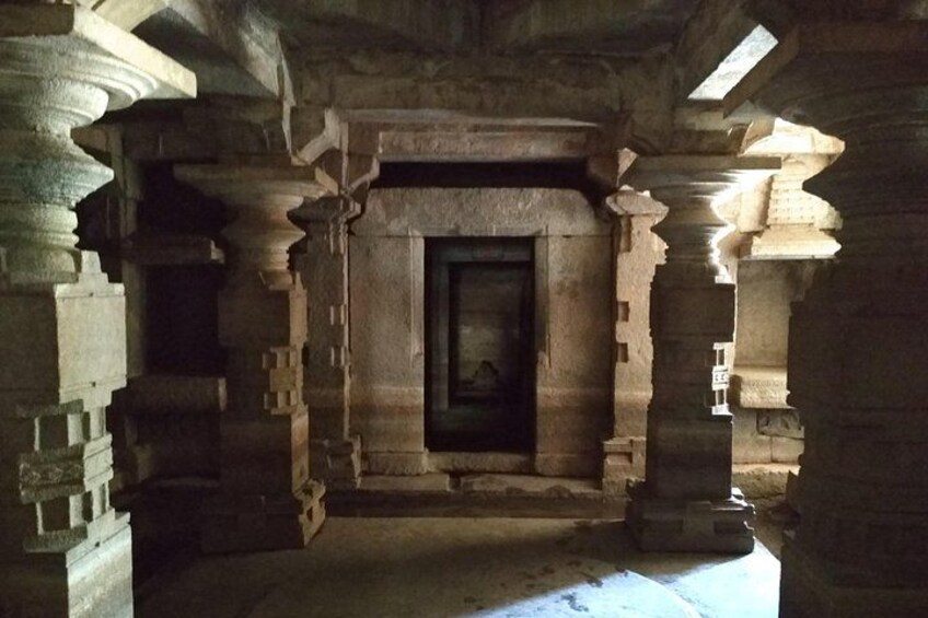 An ancient stone structure with a central doorway, flanked by ornate pillars and a vaulted ceiling. 5