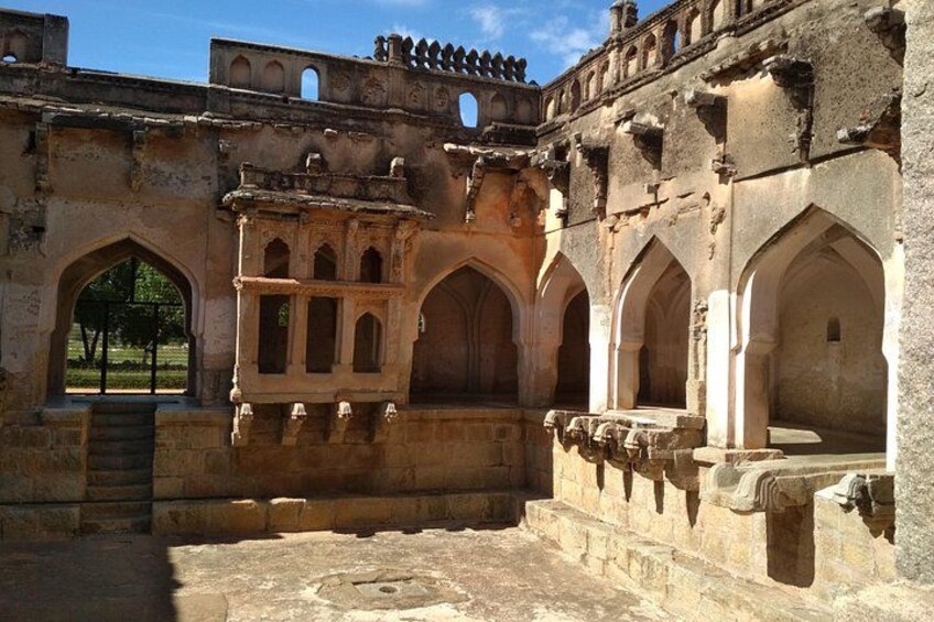 An ancient stone structure with arched windows and a central tower. 2