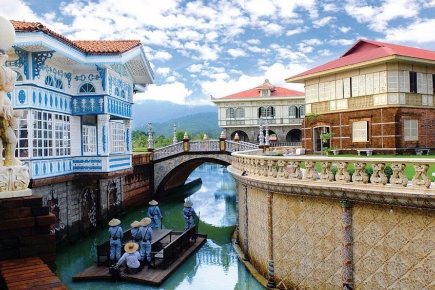 A traditional waterway with a bridge, a boat with passengers, and ornate buildings. 1