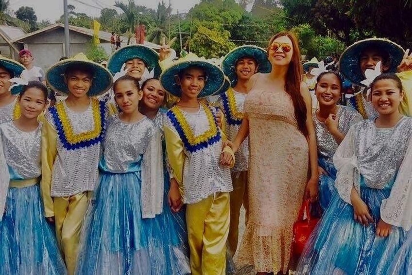 A group of people in traditional costumes with hats and floral decorations. 2