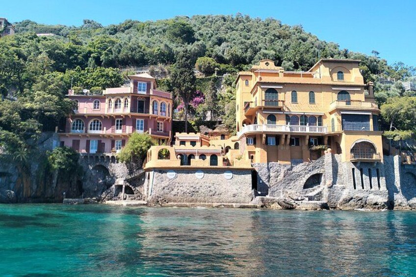 Un pueblo costero con edificios de colores, un litoral rocoso y un mar azul cristalino. 2