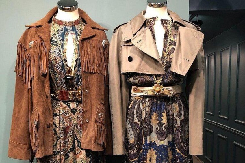 Deux mannequins vêtus de tenues d’époque, ornées de franges et de motifs. 2