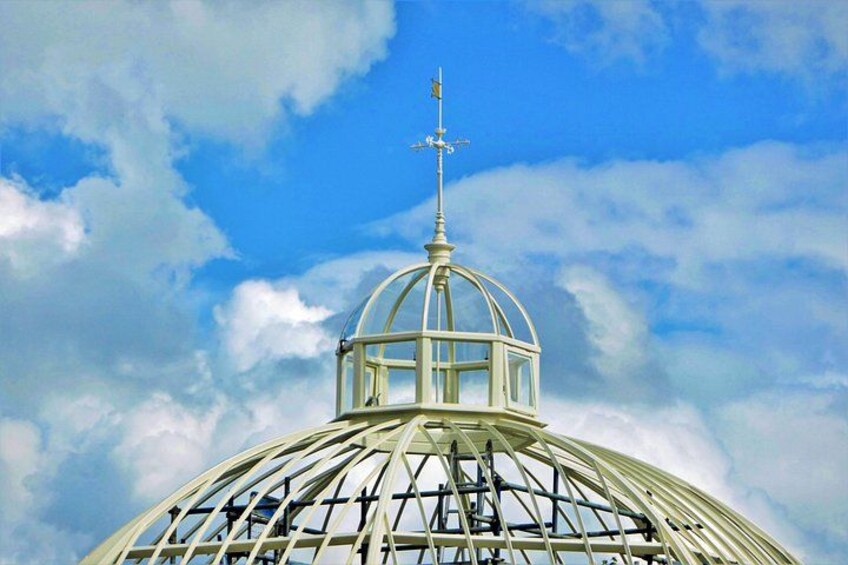 A large glass dome structure with a metal framework, set against a partly cloudy sky. 4