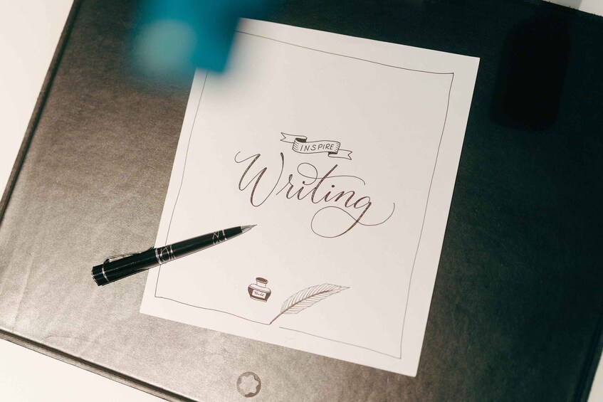 A notebook with a page titled 'Writing' and a pen on it. 2