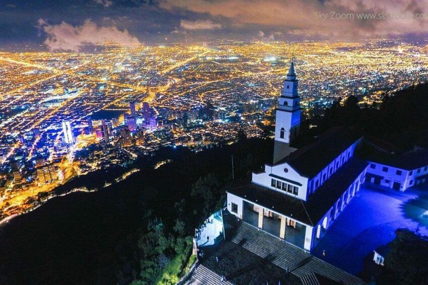 Paesaggio urbano notturno con strade illuminate e una chiesa imponente con un campanile. 4