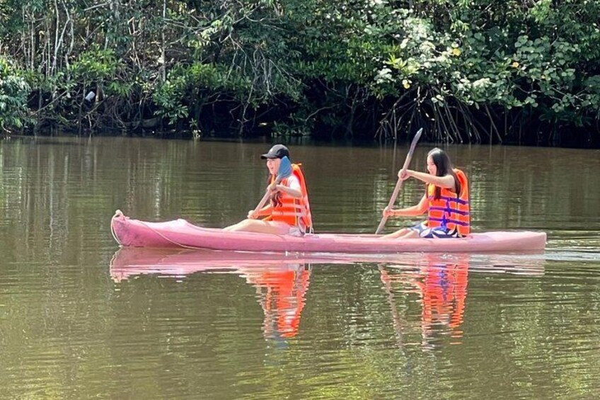 Deux personnes dans un canoë sur une rivière paisible, entourée d’une végétation luxuriante. 5