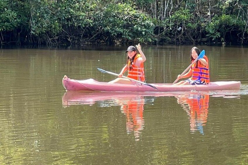 Deux personnes dans un canoë sur une rivière paisible, entourée d’une végétation luxuriante. 2