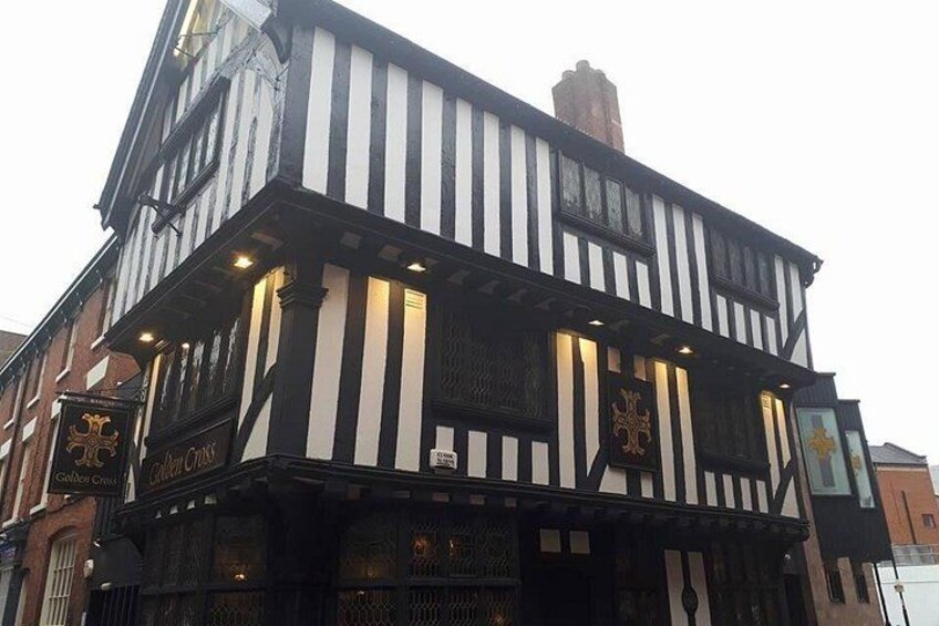A black and white striped building with a sign that reads 'Golden Cross.' 1