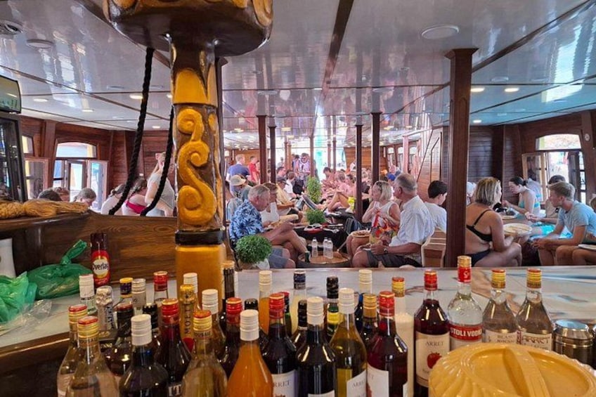 Bar en un crucero con varias botellas de alcohol y numerosos pasajeros. 2